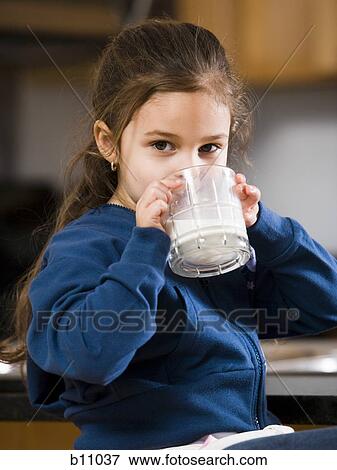 Young girl drinking a glass of milk View Large Photo Image Stock Photo - Young girl drinking a glass of milk. Fotosearch