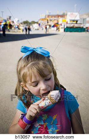 Stock Photo - Young girl eating ice cream cone. Fotosearch