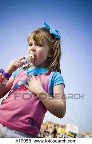 Young girl eating ice cream cone View Large Photo Image Stock Photo - Young girl eating ice cream cone. Fotosearch