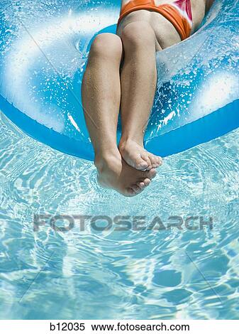 Young girl floating on life ring in swimming pool View Large Photo Image Stock Photography - Young girl floating on life ring in swimming pool. Fotosearch