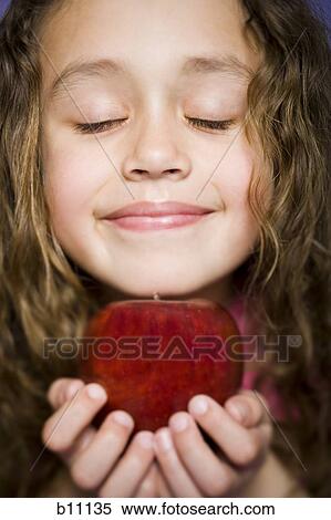 Young girl holding a red apple View Large Photo Image Stock Photography - Young girl holding a red apple. Fotosearch