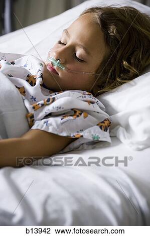 Stock Image - Young girl in hospital bed with respirator. Fotosearch