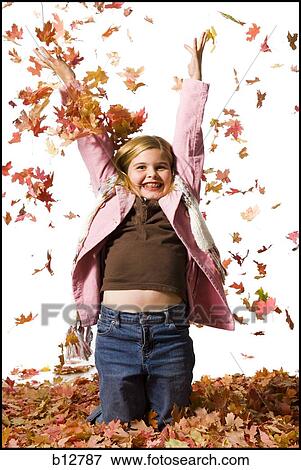 Stock Photo - Young girl playing in fallen leaves. Fotosearch
