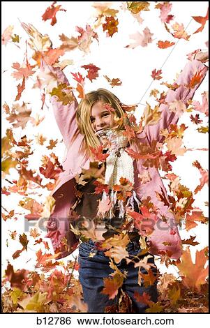 Young girl playing in fallen leaves View Large Photo Image Stock Photograph - Young girl playing in fallen leaves. Fotosearch