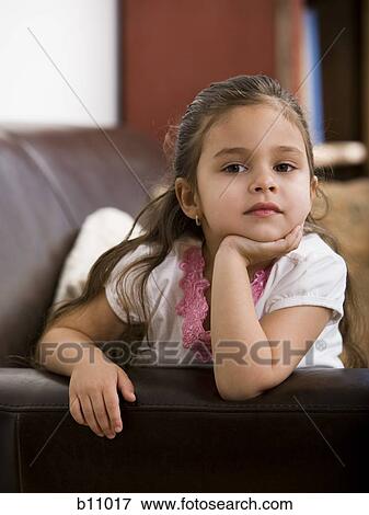 Young girl sitting on leather sofa View Large Photo Image Stock Photo - Young girl sitting on leather sofa. Fotosearch