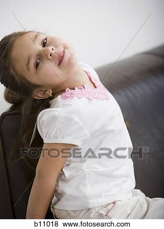 Young girl sitting on leather sofa View Large Photo Image Stock Photo - Young girl sitting on leather sofa. Fotosearch