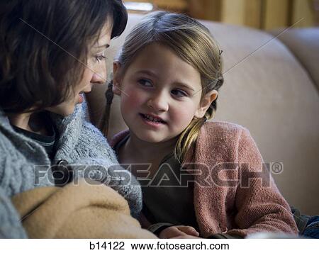 Young girl with woman sitting on sofa View Large Photo Image Stock Image - Young girl with woman sitting on sofa. Fotosearch