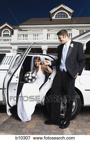 Young man holding his bride's hand and exiting a car View Large Photo Image Stock Photo - Young man holding his bride's hand and exiting a car. Fotosearch