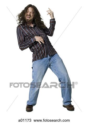 Young man sticking his tongue out and playing air guitar View Large Photo Image Stock Image - Young man sticking his tongue out and playing air guitar. Fotosearch