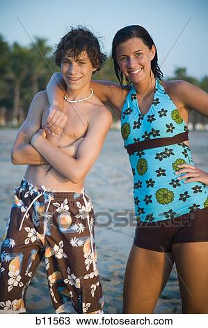 Stock Image - Young woman and little brother on beach. Fotosearch