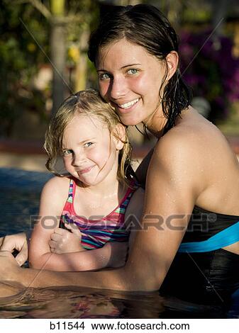 Young woman and little sister in pool View Large Photo Image Picture - Young woman and little sister in pool. Fotosearch