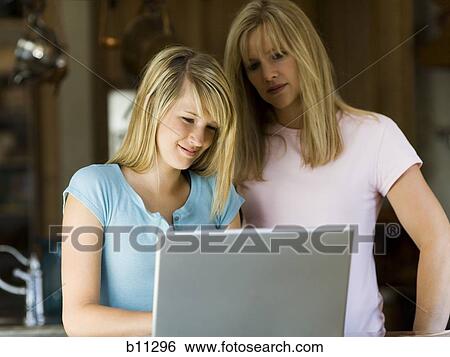 Young woman and mother working on laptop computer View Large Photo Image Stock Photograph - Young woman and mother working on laptop computer. Fotosearch
