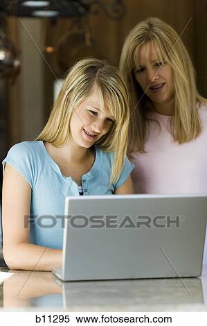 Stock Photography - Young woman and mother working on laptop computer. Fotosearch