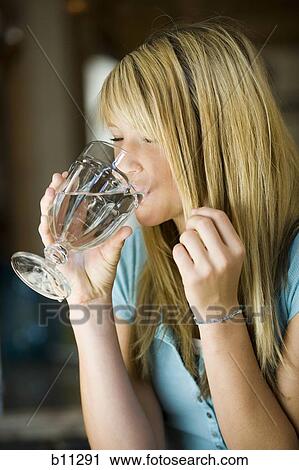 Young woman drinking a glass of water View Large Photo Image Stock Image - Young woman drinking a glass of water. Fotosearch