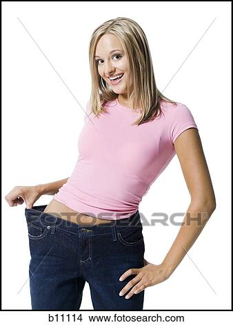 Picture - Young woman excited about weight loss. Fotosearch
