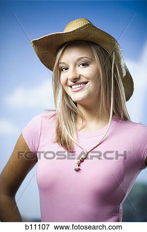 Stock Photo - Young woman wearing straw hat. Fotosearch