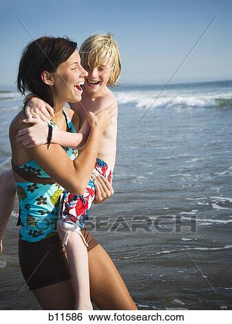 Young woman with little brother at beach View Large Photo Image Stock Photograph - Young woman with little brother at beach. Fotosearch