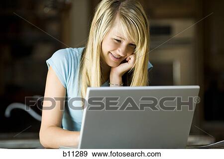 Young woman working on a laptop computer View Large Photo Image Stock Photo - Young woman working on a laptop computer. Fotosearch