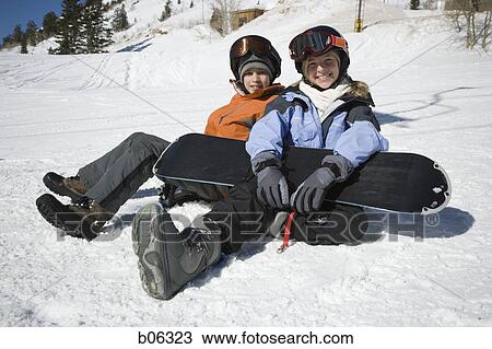 Stock Image - A brother and sister sitting in the snow. Fotosearch