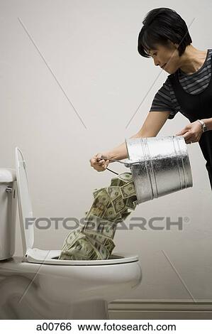 A person pouring a bucket of money down the toilet View Large Photo Image Stock Photograph - A person pouring a bucket of money down the toilet. Fotosearch
