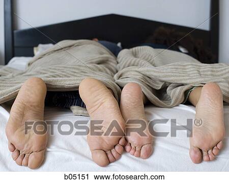 Bare feet at end of bed with headboard View Large Photo Image Stock Image - Bare feet at end of bed with headboard. Fotosearch