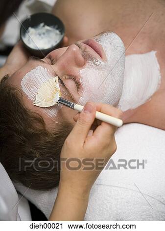 Stock Image - Beautician applying face masque. Fotosearch