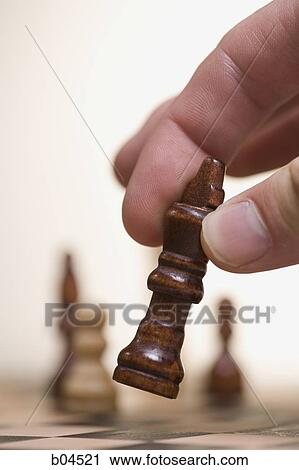 Stock Image - Bishop Chess Piece being moved. Fotosearch