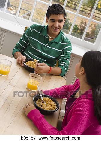Boy and girl eating breakfast View Large Photo Image Stock Photo - Boy and girl eating breakfast. Fotosearch