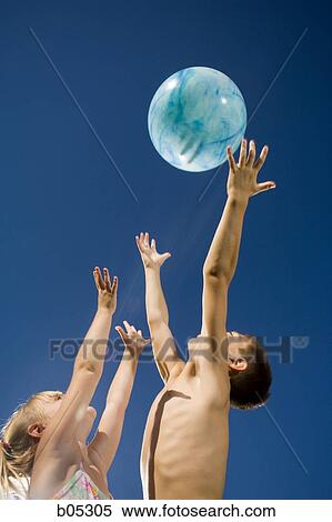 Boy and girl playing with beach ball View Large Photo Image Stock Photography - Boy and girl playing with beach ball. Fotosearch