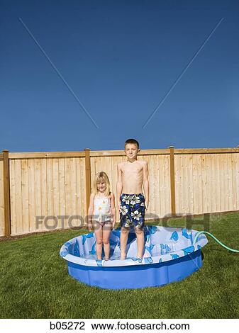 Boy and girl standing in kiddie pool View Large Photo Image Stock Image - Boy and girl standing in kiddie pool. Fotosearch