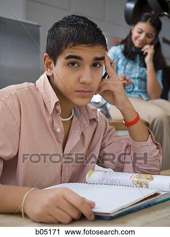 Boy doing homework with girl talking on phone View Large Photo Image Stock Image - Boy doing homework with girl talking on phone. Fotosearch