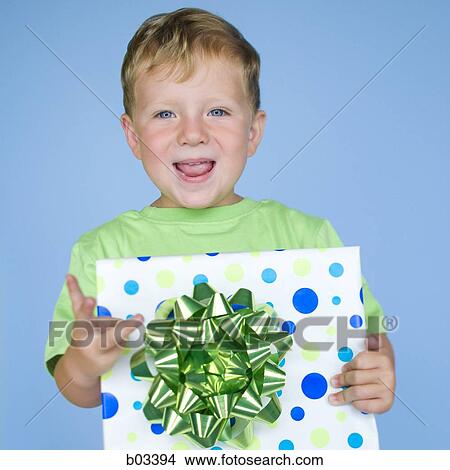 Boy holding birthday present View Large Photo Image Picture - Boy holding birthday present. Fotosearch