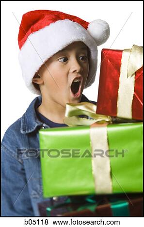 Boy in santa hat with Christmas gifts View Large Photo Image Stock Photo - Boy in santa hat with Christmas gifts. Fotosearch