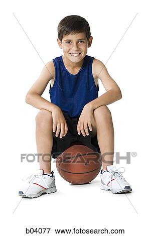 Stock Photo - Boy sitting on basketball. Fotosearch