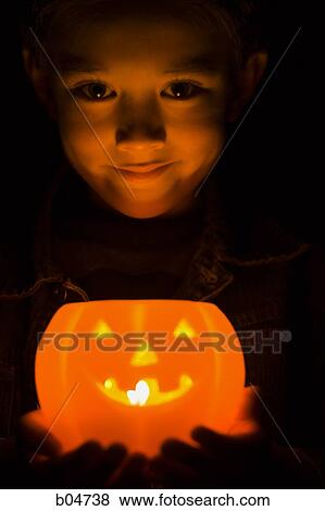 Stock Photo - Boy smiling with jack o'lantern. Fotosearch