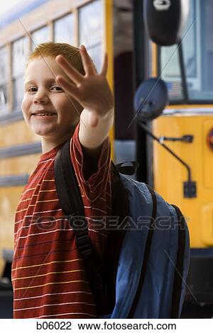 Boy waving with school bus in background View Large Photo Image Stock Image - Boy waving with school bus in background. Fotosearch
