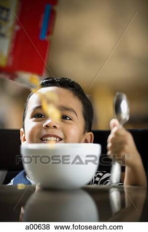 Boy with bowl of cereal and spoon smiling View Large Photo Image Stock Photo - Boy with bowl of cereal and spoon smiling. Fotosearch