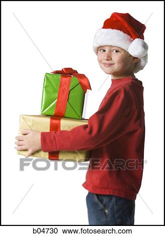 Stock Image - Boy with santa hat and Christmas gifts. Fotosearch