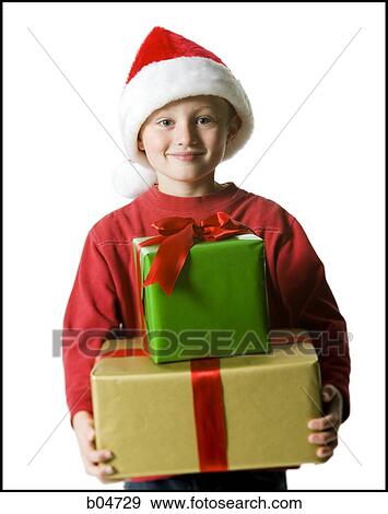 Stock Photo - Boy with santa hat and Christmas gifts. Fotosearch