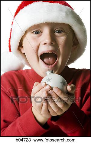 Boy with santa hat and Christmas ornament View Large Photo Image Stock Photo - Boy with santa hat and Christmas ornament. Fotosearch