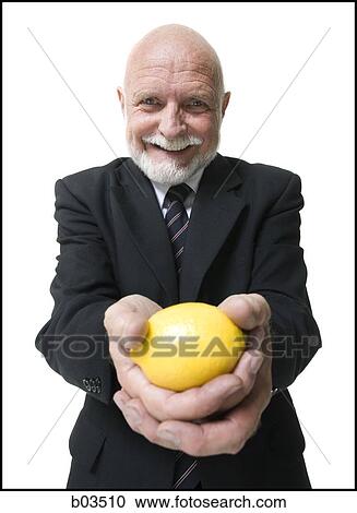 Stock Image - Business man holding lemon. Fotosearch