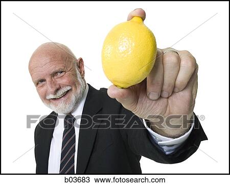 Stock Image - Business man holding lemon. Fotosearch