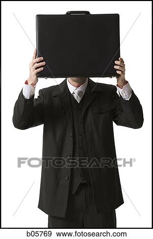 Stock Photo - Businessman holding a briefcase in front of his face. Fotosearch