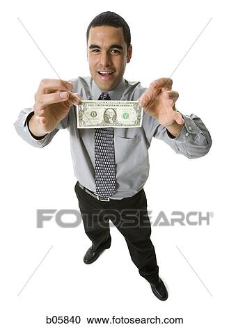 Stock Image - Businessman holding a one dollar bill. Fotosearch