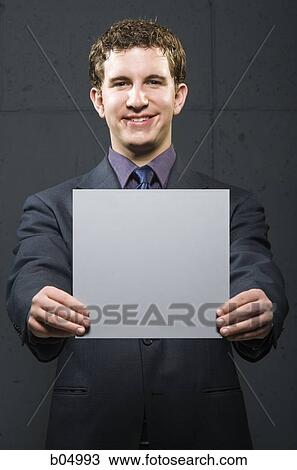 Businessman holding blank sign smiling View Large Photo Image Stock Image - Businessman holding blank sign smiling. Fotosearch