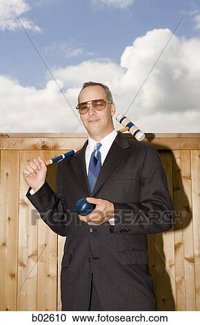 Businessman holding croquet equipment View Large Photo Image Stock Image - Businessman holding croquet equipment. Fotosearch