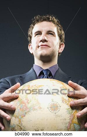 Businessman holding globe smiling View Large Photo Image Stock Image - Businessman holding globe smiling. Fotosearch
