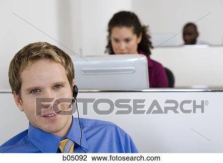 Businessman in cubicle with headset View Large Photo Image Stock Image - Businessman in cubicle with headset. Fotosearch