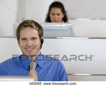 Businessman in cubicle with headset View Large Photo Image Stock Image - Businessman in cubicle with headset. Fotosearch