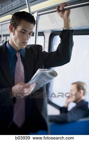 Businessman on city bus or subway reading newspaper View Large Photo Image Stock Photo - Businessman on city bus or subway reading newspaper. Fotosearch